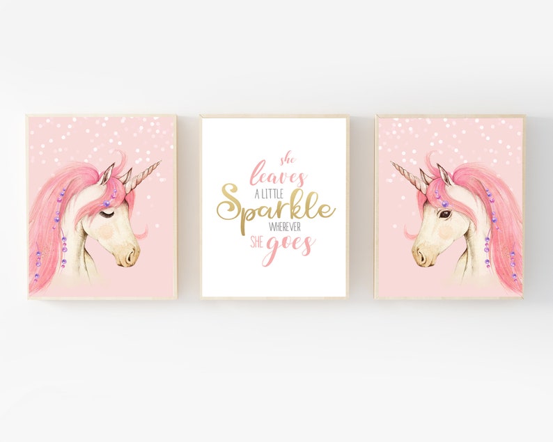 May include: Three pink and gold printable wall art prints featuring a unicorn with a pink mane and a gold horn. The middle print has the text "She leaves a little sparkle wherever she goes".