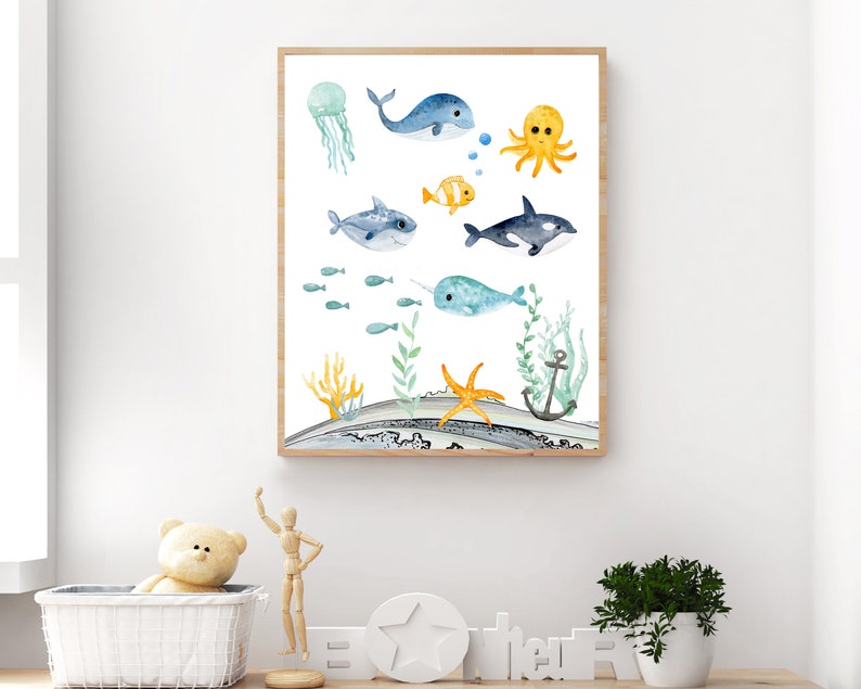 Peut inclure: Une illustration aquarelle d'une vari&eacute;t&eacute; de cr&eacute;atures marines, dont une baleine, une narval, une pieuvre, une m&eacute;duse et un poisson. L'illustration est sur un fond blanc avec une sc&egrave;ne oc&eacute;anique bleue et verte.