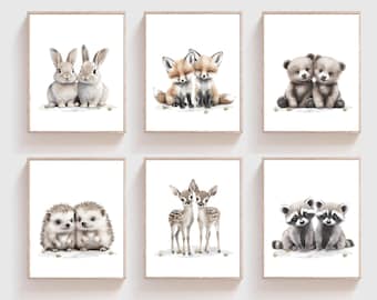 May include: Set of six framed prints featuring adorable animal pairs. Each print features a different animal pair, including bunnies, foxes, bears, hedgehogs, deer, and raccoons. The prints are all in a simple white frame with a white background.