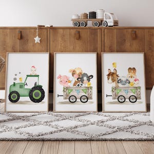 K&ouml;nnte beinhalten: Drei gerahmte Aquarell-Illustrationen von Bauernhoftieren. Die erste zeigt einen gr&uuml;nen Traktor mit einem K&uuml;ken oben drauf. Die zweite zeigt eine Kuh, ein Schwein, eine Ente und ein Schaf, die in einem Wagen fahren. Die dritte zeigt ein Pferd, ein Schaf und ein Kaninchen, die in einem Wagen fahren.