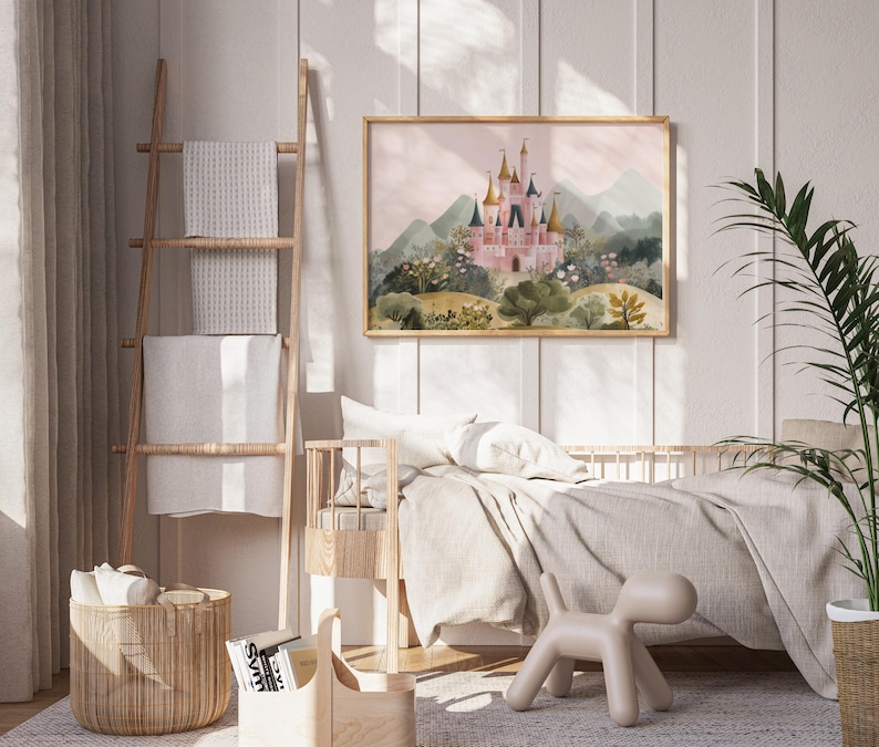 May include: A framed watercolor print of a pink castle with gold turrets, set against a backdrop of green mountains and a soft pink sky. The artwork is displayed in a light wood frame, adding a touch of elegance to the children's room decor.