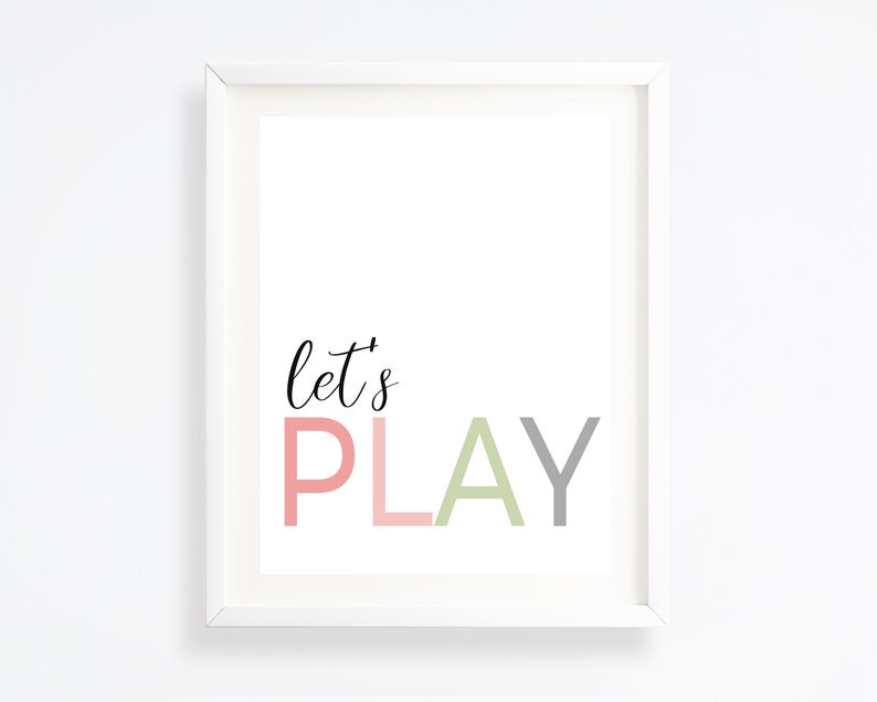 May include: White framed print with the text "let's PLAY" in pink, green, and gray lettering.