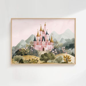May include: Watercolor painting of a pink castle with gold turrets, set against a backdrop of green mountains and a soft pink sky. The castle is surrounded by lush greenery and flowers, framed in a light wood.