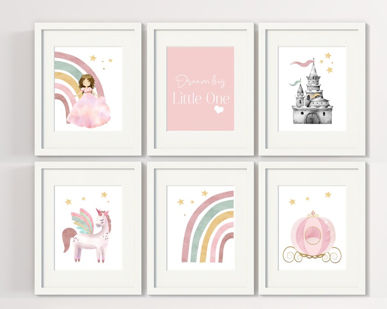 May include: Set of six printable wall art prints featuring a pink and gold color scheme. The prints include a princess with a rainbow, a unicorn, a castle, a carriage, a rainbow, and the text "Dream Big Little One".