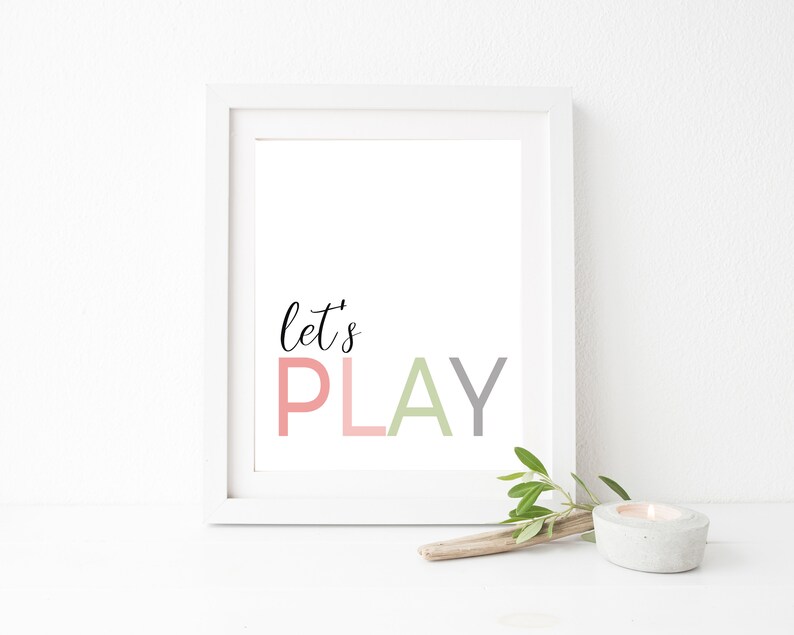 May include: White framed print with the text "let's PLAY" in pink, gray, and green lettering.