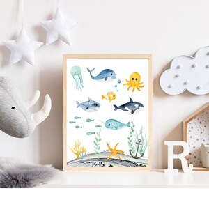 Peut inclure: Une impression aquarelle repr&eacute;sentant une vari&eacute;t&eacute; de cr&eacute;atures marines, dont une baleine, une pieuvre, une narval, un poisson et une &eacute;toile de mer. L'impression est sur fond blanc avec des accents bleus et verts.