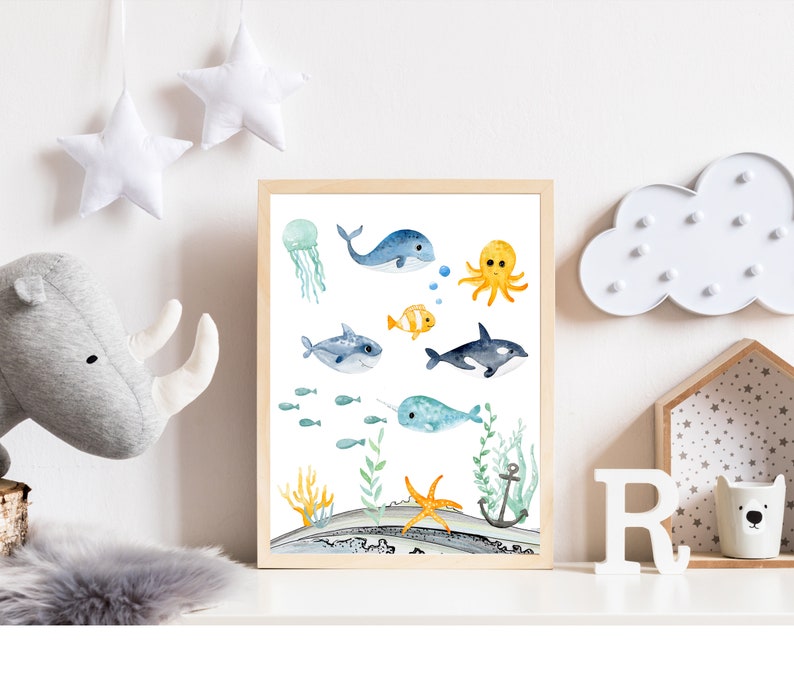 Peut inclure: Une impression aquarelle repr&eacute;sentant une vari&eacute;t&eacute; de cr&eacute;atures marines, dont une baleine, une pieuvre, une narval, un poisson et une &eacute;toile de mer. L'impression est sur fond blanc avec des accents bleus et verts.