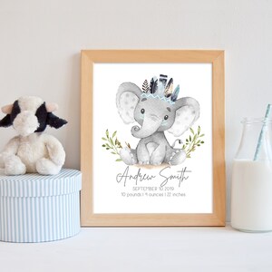 May include: A watercolor illustration of a gray elephant wearing a blue and brown feather headdress. The elephant is sitting on a white background with green leaves. The text "Andrew Smith, September 10, 2019, 10 pounds 14 ounces | 22 inches" is below the elephant.