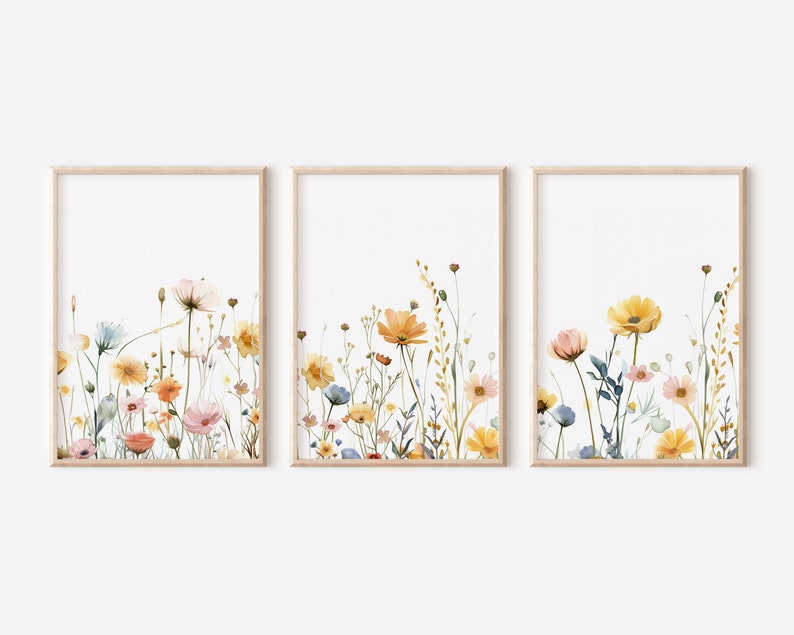 May include: Set of three framed watercolor prints featuring a floral design with yellow, orange, pink, and blue wildflowers on a white background.