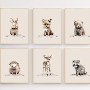May include: Set of six watercolor illustrations of baby animals, including a rabbit, fox, bear, hedgehog, deer, and raccoon. Each animal is depicted in a cute and whimsical style, with soft brown, gray, and white tones.
