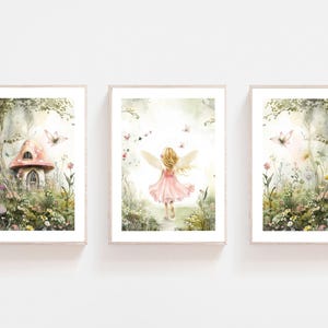 Peut inclure: Ensemble de trois impressions encadrées à l'aquarelle sur le thème des fées. Les impressions représentent une fée en robe rose, une maison champignon et une scène de forêt avec des papillons. L'œuvre a une palette de couleurs pastel.