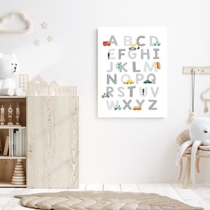 Puede incluir: Un p&oacute;ster de alfabeto blanco y gris con veh&iacute;culos coloridos y se&ntilde;ales de tr&aacute;fico. Las letras est&aacute;n en una fuente gris y los veh&iacute;culos son de varios colores, incluyendo rojo, azul, amarillo y verde. El p&oacute;ster est&aacute; colgado en una pared blanca en una guarder&iacute;a.