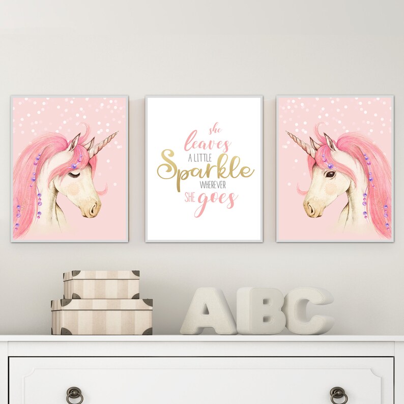 May include: Three pink and gold framed prints featuring a unicorn illustration and the text "She leaves a little sparkle wherever she goes".