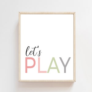 May include: A framed print with the text "Let's Play" in a playful font. The word "Play" is in pink, green, and gray.