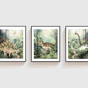 K&ouml;nnte beinhalten: Drei gerahmte Drucke von Aquarell-Illustrationen von Dinosauriern in einer Dschungelkulisse. Der erste Druck zeigt einen Stegosaurus, der zweite Druck zeigt einen Tyrannosaurus Rex und der dritte Druck zeigt einen Brachiosaurus.