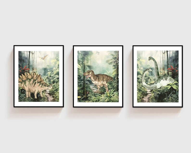 K&ouml;nnte beinhalten: Drei gerahmte Drucke von Aquarell-Illustrationen von Dinosauriern in einer Dschungelkulisse. Der erste Druck zeigt einen Stegosaurus, der zweite Druck zeigt einen Tyrannosaurus Rex und der dritte Druck zeigt einen Brachiosaurus.