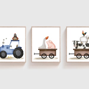 K&ouml;nnte beinhalten: Set aus drei gerahmten Aquarelldrucken mit Bauernhoftieren. Ein blauer Traktor mit einem Vogel, ein Wagen mit einer Gans und einem Schwein und ein Wagen mit einer Kuh, einem Schaf und einem Hahn. Die Drucke haben einen wei&szlig;en Hintergrund.