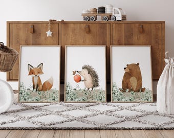 May include: Three framed illustrations of woodland animals: a fox, a hedgehog holding an apple, and a bear. Each illustration is set against a background of green foliage.