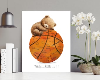 May include: A brown teddy bear sleeping on top of an orange basketball with white lines. The basketball is covered in handwritten names. The text "Welcome little one!!!" is written below the basketball.