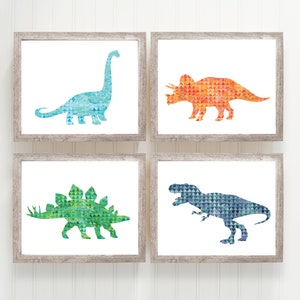 May include: Set of four framed prints featuring watercolor dinosaur silhouettes in a geometric pattern. The dinosaurs are a blue brachiosaurus, an orange triceratops, a green stegosaurus, and a blue T-Rex.