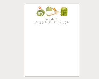 Może przedstawiać: Biały notes z imieniem Annabelle i tekstem "things to do while having matcha" nadrukowanym na nim. Notes zawiera zielono-białą ilustrację napoju matcha, trzepaczki i stosu mochi.