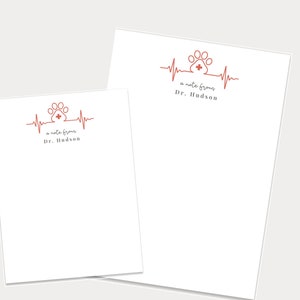 May include: Two white note cards with a red paw print and heartbeat design. The text on the cards reads "a note from Dr. Hudson".