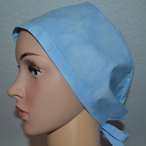 May include: A light blue surgical scrub cap with a tie at the back.