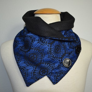 Puede incluir: Una bufanda de cuello de pico azul y negro con dos botones negros. La bufanda está hecha de una tela suave y cómoda y tiene un forro polar cálido.