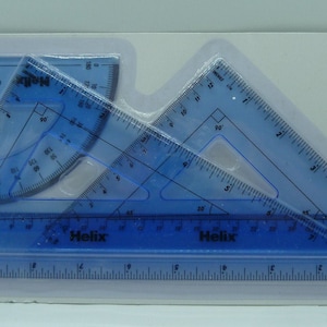 May include: A set of four blue plastic geometry tools, including a protractor, two set squares, and a ruler. The tools are packaged in a clear plastic sleeve with the brand name "Helix" and the text "Geometry Set Large" printed on it.
