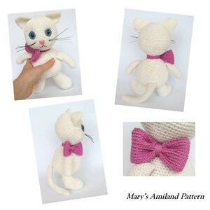 May include: White crocheted cat with pink bow tie. The cat is sitting on a white surface. The cat is looking to the right. The cat has blue eyes. The cat is wearing a pink bow tie. The cat is crocheted. The cat is sitting on a white surface. The cat is looking to the right. The cat has blue eyes. The cat is wearing a pink bow tie. The cat is crocheted.