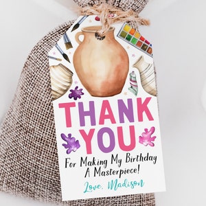 May include: A pink and purple thank you tag with a watercolor illustration of art supplies, including paintbrushes, a paint palette, and a clay pot. The tag says "Thank You" in large pink and purple letters and "For Making My Birthday A Masterpiece! Love, Madison".