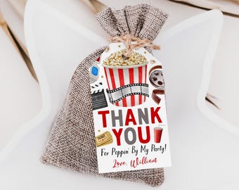 May include: A brown burlap drawstring favor bag with a rectangular white tag featuring a red and white striped popcorn bucket, film strip, 3D glasses, and tickets. The text reads: THANK YOU For Poppin' By My Party! Love, William.