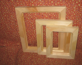 May include: Three wooden picture frames of different sizes, nested inside each other. The frames are made of natural wood with a light brown color. The largest frame is on the bottom, and the smallest frame is on top.