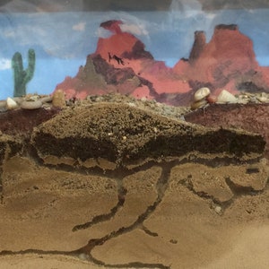 May include: A cross-section of an ant farm, showing the tunnels and chambers of an ant colony. The top of the farm features a desert landscape with a cactus and red rock formations.