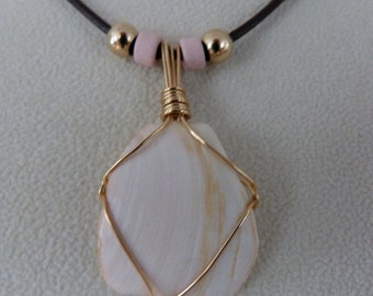 Seashell wrapped in 14k gold-filled wire on brown leather cord.