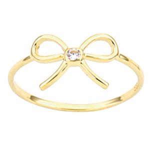 Könnte beinhalten: Ein goldener Ring mit einem zarten Schleifendesign und einem kleinen, klaren Stein in der Mitte.