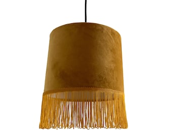May include: A gold pendant light with a mustard yellow velvet shade and a gold fringe trim.