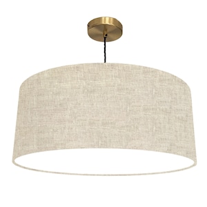 Peut inclure: Un luminaire suspendu en forme de tambour en lin beige avec une fixation au plafond en laiton.