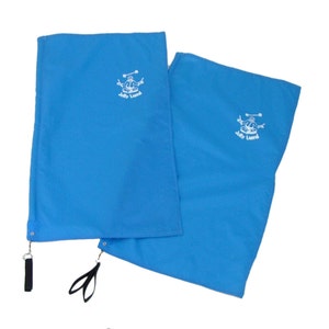 May include: Two blue fabric placemats with a white embroidered logo of a person holding a drum and the text "Jolly Llama". The placemats have black straps attached to the corners.