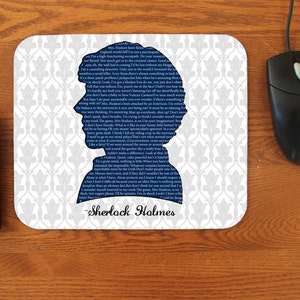 May include: A white mouse pad with a blue silhouette of Sherlock Holmes. The silhouette is made up of text from the show. The text reads "Sherlock Holmes".