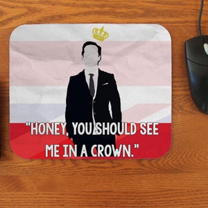 May include: A mouse pad with a red, white, and blue background. A silhouette of a person wearing a suit and a crown is in the center of the mouse pad. The text "HONEY, YOU SHOULD SEE ME IN A CROWN." is printed on the mouse pad.