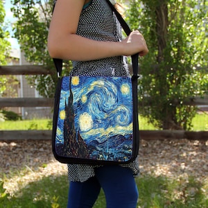 May include: A black canvas messenger bag featuring a print of Vincent van Gogh's "Starry Night" painting. The bag has a long adjustable strap and a flap closure.
