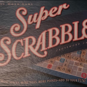 Pode incluir: Uma caixa do jogo de palavras cruzadas Super Scrabble. A caixa é azul escuro com as palavras "Super Scrabble" em letras grandes, estilizadas, vermelhas e brancas. O tabuleiro e as peças do jogo são visíveis, com o texto "Mais espaços, mais peças, mais pontos - adicione à sua diversão!"