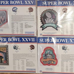 May include: Four Super Bowl patches, each featuring a different year and team. The patches are framed and displayed on a white background. The patches are from Super Bowls XXV, XXVI, XXVII, and XXVIII.