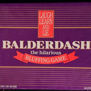 Könnte beinhalten: Violette Spieleschachtel mit goldenen Verzierungen und dem Titel "BALDERDASH" in weißen Buchstaben. Der Untertitel lautet "the hilarious BLUFFING GAME". Die Schachtel enthält außerdem den Text "LAUGH LEARN AND LIE" in einem roten Kasten sowie "2 TO 6 PLAYERS OR MORE" und "AGES 10 TO ADULT" am unteren Rand.