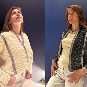 May include: Two crochet jackets are displayed. One is cream-colored with gray trim, the other is black with silver trim. Both jackets have a textured pattern and are open-fronted. The jackets are worn over a white top and paired with white pants.