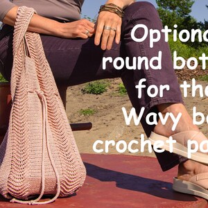 May include: A light pink crocheted bag with a drawstring closure. The bag has a wavy pattern and is held by a person sitting on a red bench. Text on the image reads "Optional round bottom for the Wavy bag crochet pattern."