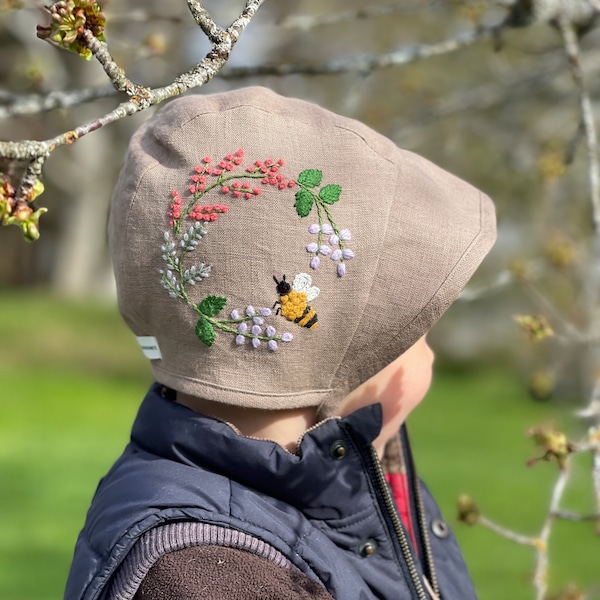 Очаровательная и натуральная: льняная детская шапочка ручной работы с цветочной вышивкой, шерстяными растениями и козырьком