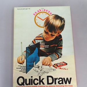 May include: A vintage "Quick Draw" drawing kit box cover. The cover features a young child using the kit, with the text "Quick Draw" in large, bold letters. The kit includes a projection prism to make drawing easier. The cover also includes the text "boys and girls age 7-15".