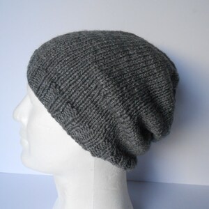 May include: A gray knitted beanie hat with a ribbed texture.